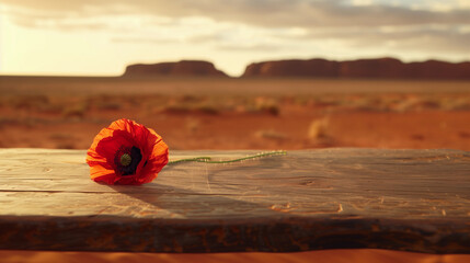 Red poppy flower in outback Ulluru landscape wood table ANZAC Remembrance day Australia New Zealand least we forget for war heroes military army navy airforce WW1 dawn service poppies blank copy space
