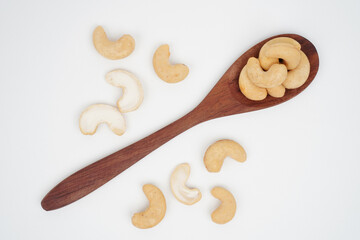 Cashew nuts and wooden spoon isolated background