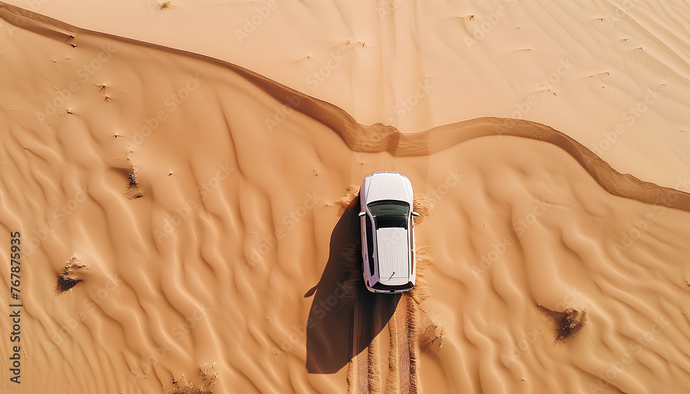 Wall mural car moves through deep sand in the desert top view