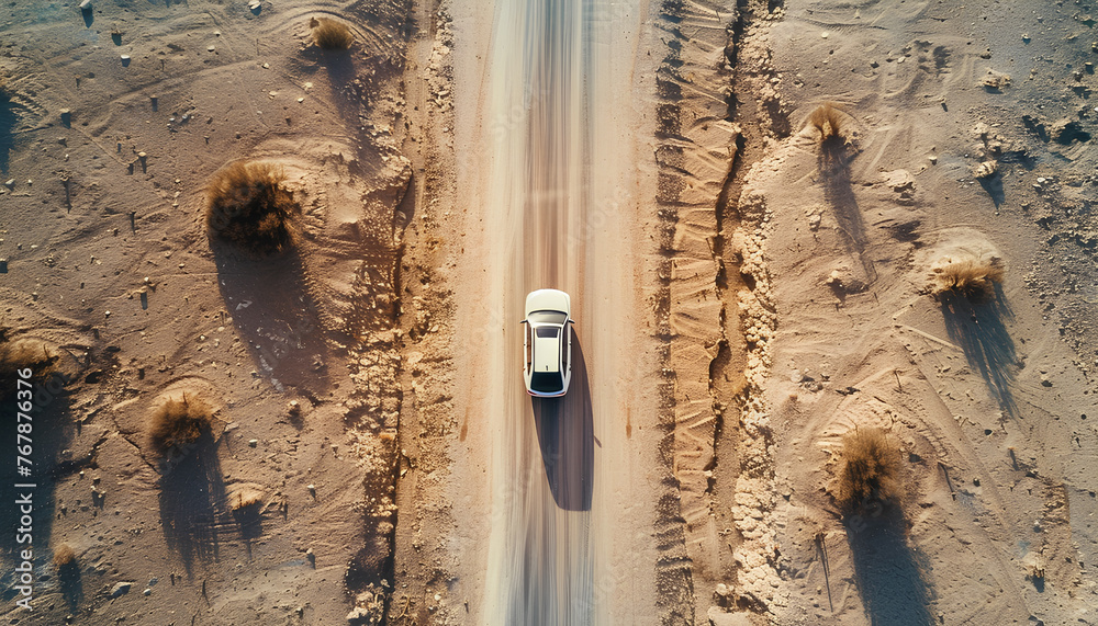 Poster car moves along an asphalt road in the desert top view