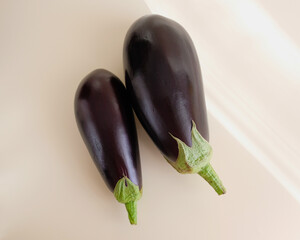Eggplants are in the center of the photo. Two fresh vegetables