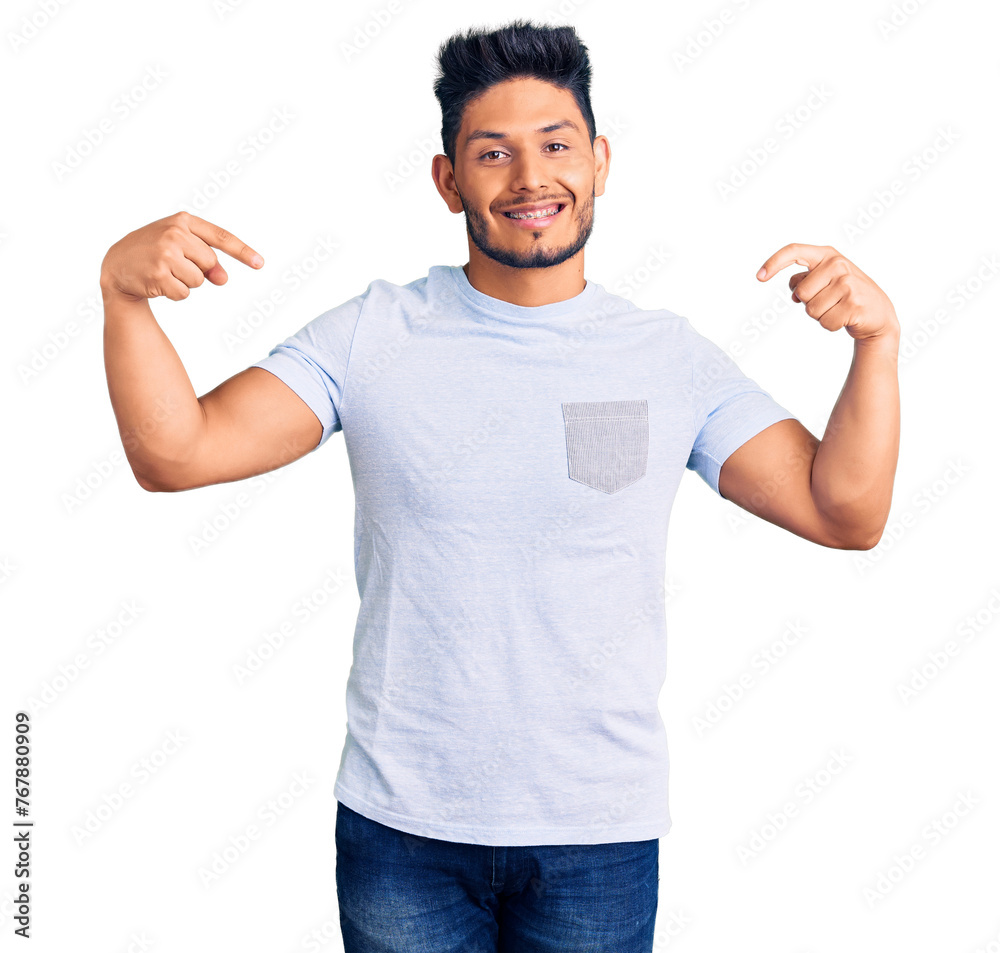 Wall mural handsome latin american young man wearing casual clothes looking confident with smile on face, point