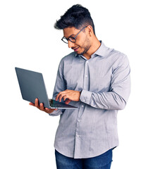 Handsome latin american young man working using computer laptop looking positive and happy standing...