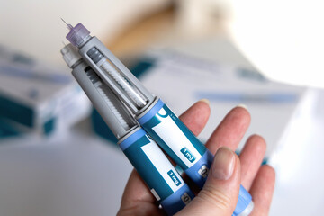 Hand holding Ozempic Insulin injection pen for diabetics.