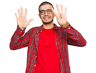 Hispanic young man wearing casual clothes showing and pointing up with fingers number nine while...