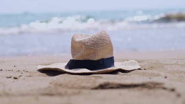 A straw hat rests on the beach, evoking visions of seaside resorts and eco-friendly tourism. Discover serenity and sustainability at coastal destinations.