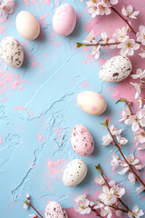 Top-down view of Easter eggs and cherry blossoms on pastel background, ideal for spring holiday themes.