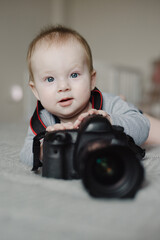 Little boy photographer lying with camera at home - 767893943