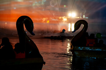 People in a swan shaped boat enjoying the light, sound and fountains show at Gadisar lake showing...