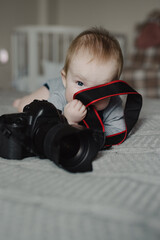 Little boy photographer lying with camera at home - 767895173