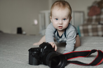 Little boy photographer lying with camera at home - 767896362