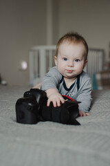 Little boy photographer lying with camera at home - 767897142