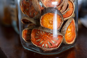 Selective focus dried bael fruit in a clear glass jar. Dried bael fruit, a Thai herb that nourishes...