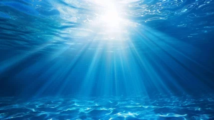 Foto auf Alu-Dibond Ocean background - Sun shining light sunlight sunshine in blue clearly deep water, sunbeams illuminate the blue underwater sea scene © Corri Seizinger