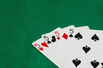 A pile of Poker playing card, playing cards on green background.;
