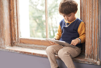 Home, tablet and serious child on internet, app or game on website for learning by windowsill....