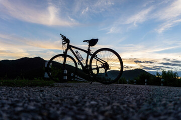 Bicycle Silhouette Against Twilight Sky and Hills