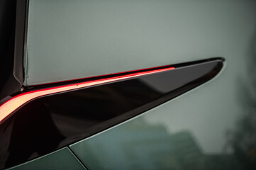 Red tail lights closeup. Modern concept super car exterior design detail - headlight. Back view....