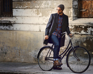 Fototapeta premium Bicycle, vintage and man in city for travel on winter vacation, adventure or holiday with retro style. Fashion, stylish and male person on bike for cycling with beanie and coat for outfit in town.