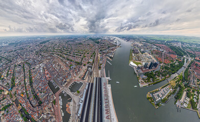 Amsterdam, Netherlands. Central Railway Station. Panorama of the city on a summer morning in cloudy weather. Aerial view