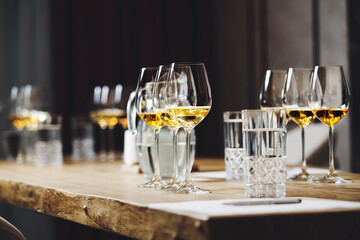 Elegant wine glasses with different white and sparkling wines on the table during the preparation for the tasting.