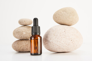 Glass brown bottle is in front of spa stones pyramids. - 767920736
