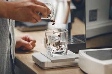 Barista Precisely Measures Roasted Coffee Beans for Grinding at Modern Cafe Counter