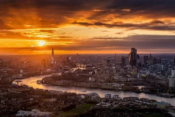 Papier Peint photo Tower Bridge Elevated view of a beautiful sunset with orange and red colors behind the urban skyline of London, England, with River Thames and City buildings