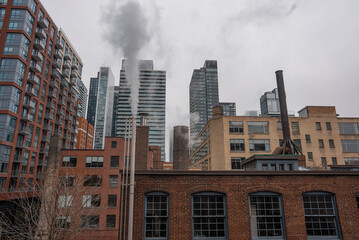 Fototapeta na wymiar chimney pipe with steam at New York or Toronto, smoke stack on big city with skyscrapers urban background