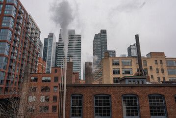 chimney pipe with steam at New York or Toronto, smoke stack on big city with skyscrapers urban background