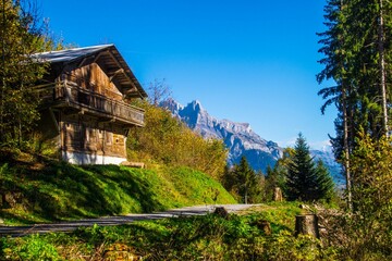 Wooden house situated in a valley with majestic mountains in the background. France.