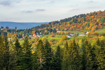 Rural autumn landscape with a village surrounded by colorful trees. Krahule, Slovakia.