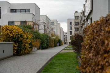 a street with some apartment buildings in the background and a walkway in front of it