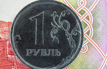 Close-up of a Russian one ruble coin against the background of a paper banknote. Concept of money, finance, cooperation, exchange rate and trade. Flat lay, macro, top view, mockup