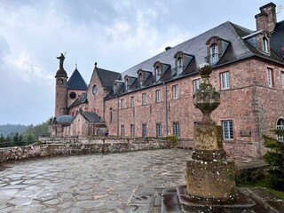 Majestic red brick castle-like Mont Sainte-Odile
building against a clouded sky
