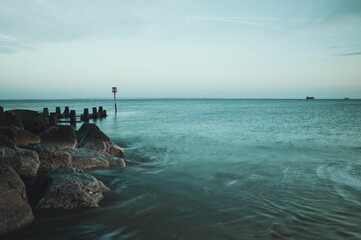 Picturesque pathway of rocky terrain winds along the shoreline of a tranquil body of water