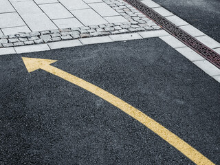 Yellow Arrow on Asphalt Guiding Direction in a Swedish Street