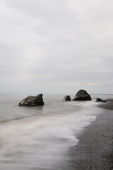 Fototapeta na wymiar Water waves of the Black Sea crashing on rocks on the stony shore, coast - close up, nobody, no people. Nature, element, landscape