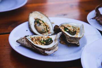 Vietnamese cuisine shellfish with nuts on a white plate.