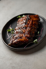 Grilled ribs with radish and microgreen on a plate