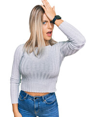 Fototapeta premium Beautiful blonde woman wearing casual clothes surprised with hand on head for mistake, remember error. forgot, bad memory concept.