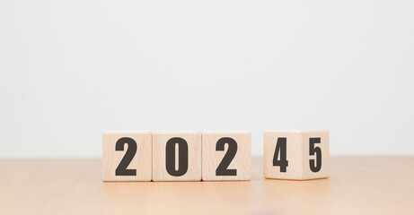 Wooden block with numbers 2024 2025 on wooden table with white background, New Year 2025 concept