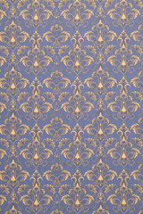 Old wallpaper on the wall. Old wallpaper for texture or background.