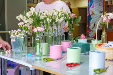 A florist is preparing a workplace for a master class for children on assembling bouquets of...