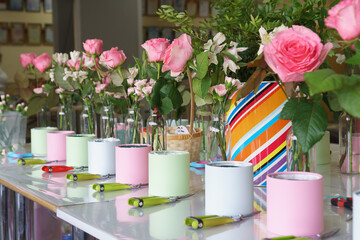 Secateurs, boxes and flowers in vases are being prepared for a master class on assembling bouquets. No people.