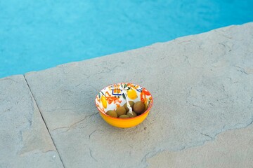 Closeup of a bowl of green olives by a pool in Tuscany