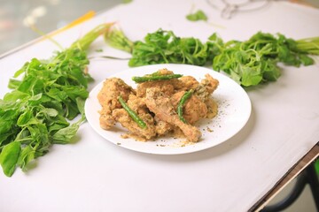White plate of roasted chicken with fresh vegetables garnish.