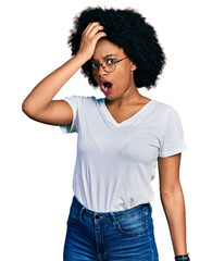 Young african american woman wearing casual white t shirt surprised with hand on head for mistake, remember error. forgot, bad memory concept.