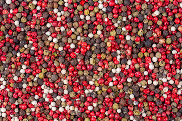 Pepper mix. Heap of black, red, white and allspice peppercorns isolated on white background, close...