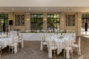 Empty wedding reception area set up with tables, ready for guests to arrive